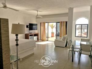a living room with a bed and a dining room at Pelicano Inn Playa del Carmen - Beachfront Hotel in Playa del Carmen