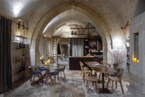 un restaurante con mesas y sillas en una pared de piedra en Le Dimore Dell' Idris, en Matera