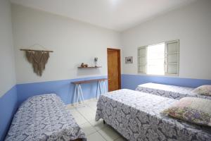 2 Betten in einem Zimmer mit blauen und weißen Wänden in der Unterkunft Casa dos Arcos Hospedaria in São João Batista do Glória