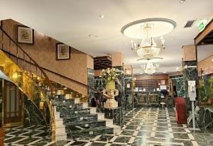 a lobby of a hotel with stairs and a chandelier at Hotel Imperial in Valladolid