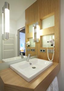 a bathroom with a white sink and a mirror at Hotel Erholung in Kellenhusen