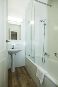 a white bathroom with a sink and a shower at Hotel Bryghia in Bruges
