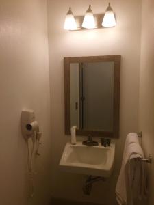 a bathroom with a sink and a mirror at Hotel Focus SFO in South San Francisco