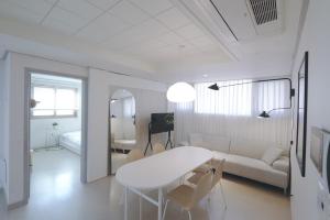 a white living room with a table and a couch at Lovely House Hongdae in Seoul