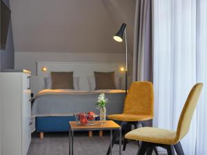 ケレンフーゼンにあるHotel Erholungのベッド、テーブル、椅子が備わるホテルルームです。