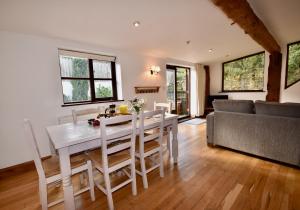 a kitchen and living room with a white table and chairs at The Cote is a stunning rural barn beach 3 miles in Ryde