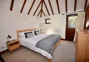 a bedroom with a large white bed and a window at The Cote is a stunning rural barn beach 3 miles in Ryde