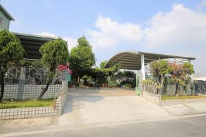 a building with a gate in front of a street at Bridgeside Homestay in Pingtung City