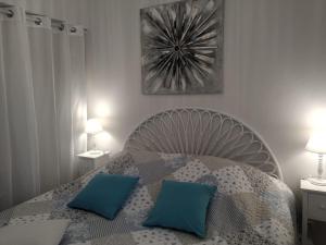 a bedroom with a bed with two blue pillows at FLOTS DE L ISLE in LʼIsle-sur-la-Sorgue