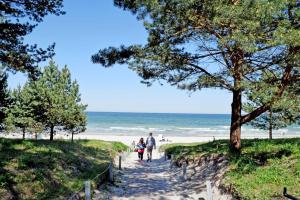 a man and two children walking down a path to the beach at Ferienwohnung Karow in Karow