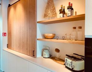 una cocina con armarios de madera y tostadora en una encimera en Koekeloeren en Hooglede