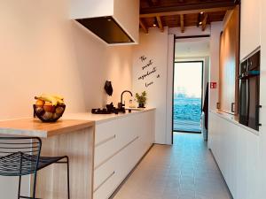 a kitchen with white cabinets and a counter with a chair at Koekeloeren in Hooglede