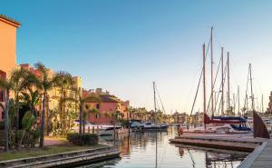 eine Gruppe von Booten, die in einem Hafen mit Gebäuden vor Anker liegen. in der Unterkunft Hotel Patricia in Torreguadiaro