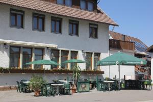 a group of tables with green umbrellas in front of a building at Gasthaus Pflug in Reint