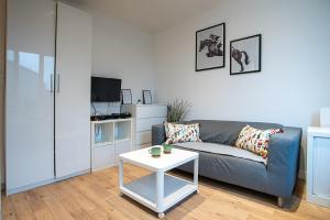 a living room with a couch and a table at Apartments au Dream of horse, Dream of golf, Proche Hippodrome, Saint Cloud in Saint-Cloud