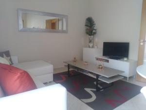 ein Wohnzimmer mit einem Sofa und einem TV in der Unterkunft Almancil Park Apartment in Almancil