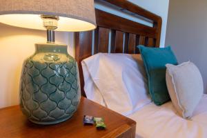 una lámpara en una mesa junto a una cama en Casa Rural as Bentinas, en Milladoiro