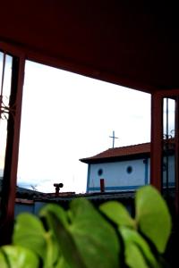 ein Haus mit einem Kreuz auf dem Dach eines Gebäudes in der Unterkunft Casa dos Arcos Hospedaria in São João Batista do Glória