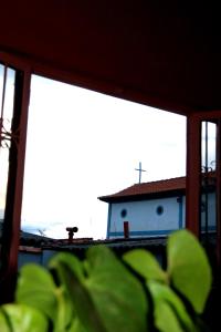 a house with a cross on the roof of a building at Casa dos Arcos Hospedaria in São João Batista do Glória