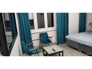 ein Schlafzimmer mit 2 Stühlen, einem Bett und einem Tisch in der Unterkunft Slatka Tajna in Banja Luka
