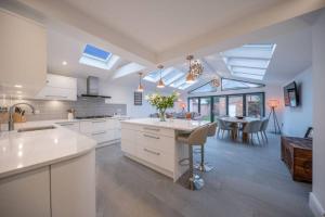 a kitchen with white cabinets and a dining room with a table at Total Luxury in the Heart of Stratford upon Avon in Stratford-upon-Avon