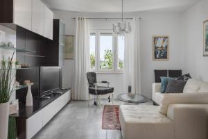 sala de estar con sofá blanco y TV en Villa OLD OLIVE, 3lovelyvillas, en Podgora