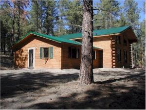 a wooden cabin with a tree in front of it at Desperado in Custer