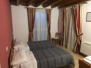 um quarto com uma cama e uma janela com cortinas em IL Borgo em Módena