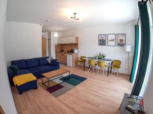 ein Wohnzimmer mit einem blauen Sofa und einem Tisch in der Unterkunft Willa VITA in Muszyna