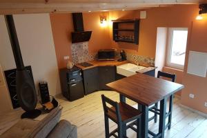 a kitchen with a wooden table and a stove at Echappée romantique in La Chapelle-Hermier