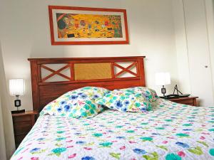 a bed with a colorful comforter and two pillows at Santiago Center Apart in Santiago