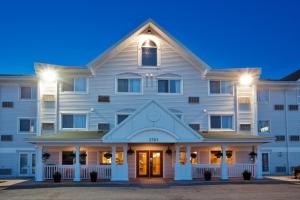 an exterior view of the inn at night at Travelodge Suites by Wyndham Regina - Eastgate Bay in Regina