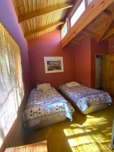 two beds in a room with purple walls at Pisco Elqui HolidayHome in Pisco Elqui