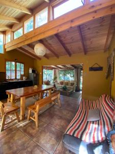 Pisco Elqui HolidayHome في بيسكو إلكي: غرفة معيشة مع طاولة وكراسي خشبية