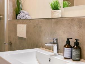 - un lavabo dans la salle de bains avec 2 bouteilles d'odorisants dans l'établissement Apartment an der Altstadt (#5), à Hameln