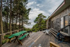 Holiday BeachにあるAlicia's Beach Houseのピクニックテーブルとベンチ付きのデッキ