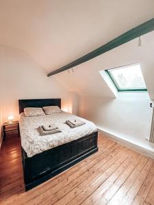 ein Schlafzimmer mit einem Bett und einem Dachfenster in der Unterkunft Chambres Privées dans une maison de charme in Saint-Brice-sous-Forêt