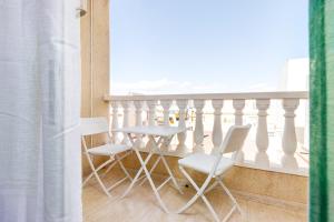 una mesa y sillas en una habitación con balcón en Casa Godisa, en Torrevieja