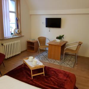a living room with a tv and a table and chairs at Dom Pod Jeleniem in Łeba