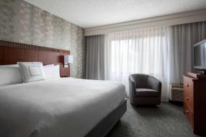 a hotel room with a bed and a chair and a television at Sonesta Select Los Angeles LAX El Segundo in El Segundo