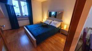 a small bedroom with a bed and a mirror at Apartament Sprężynka in Mrągowo