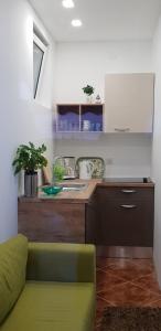 a kitchen with a green couch and a counter at Vikendica Nika in Rab