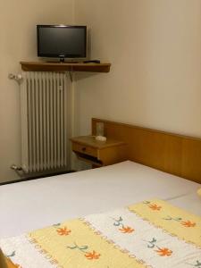 a bedroom with a bed and a tv on the wall at Grüne Au Hotel in Hasselroth