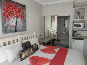 a bedroom with a large bed with a red blanket at Chic Breeze in Bloemfontein