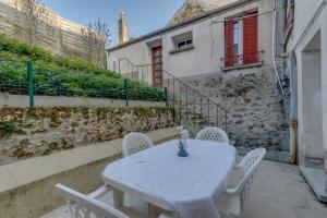 a white table and chairs in front of a building at L'Arpajonnais 6 Cosy Hyper Centre Terrasse N20 in Arpajon