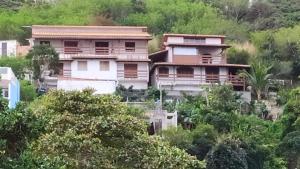 uma casa no lado de uma colina com árvores em Estalagem Vista Mar em Arraial do Cabo