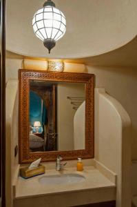 a bathroom with a sink and a mirror at Riad Merzouga in Marrakech