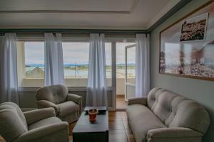 a living room with two couches and a large window at ABC DEPARTAMENTOS in Ushuaia
