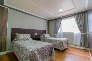 um quarto de hotel com duas camas e uma janela em ABC DEPARTAMENTOS em Ushuaia