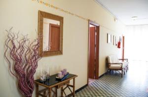 un pasillo con una mesa y una pintura en la pared en Hotel Astoria, en Riccione